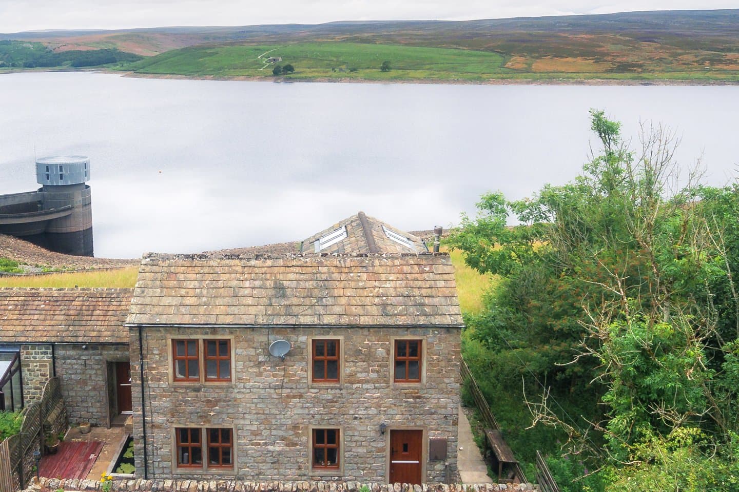 The stone exterior of Grimwith House on the shore of Grimwith Reservoir