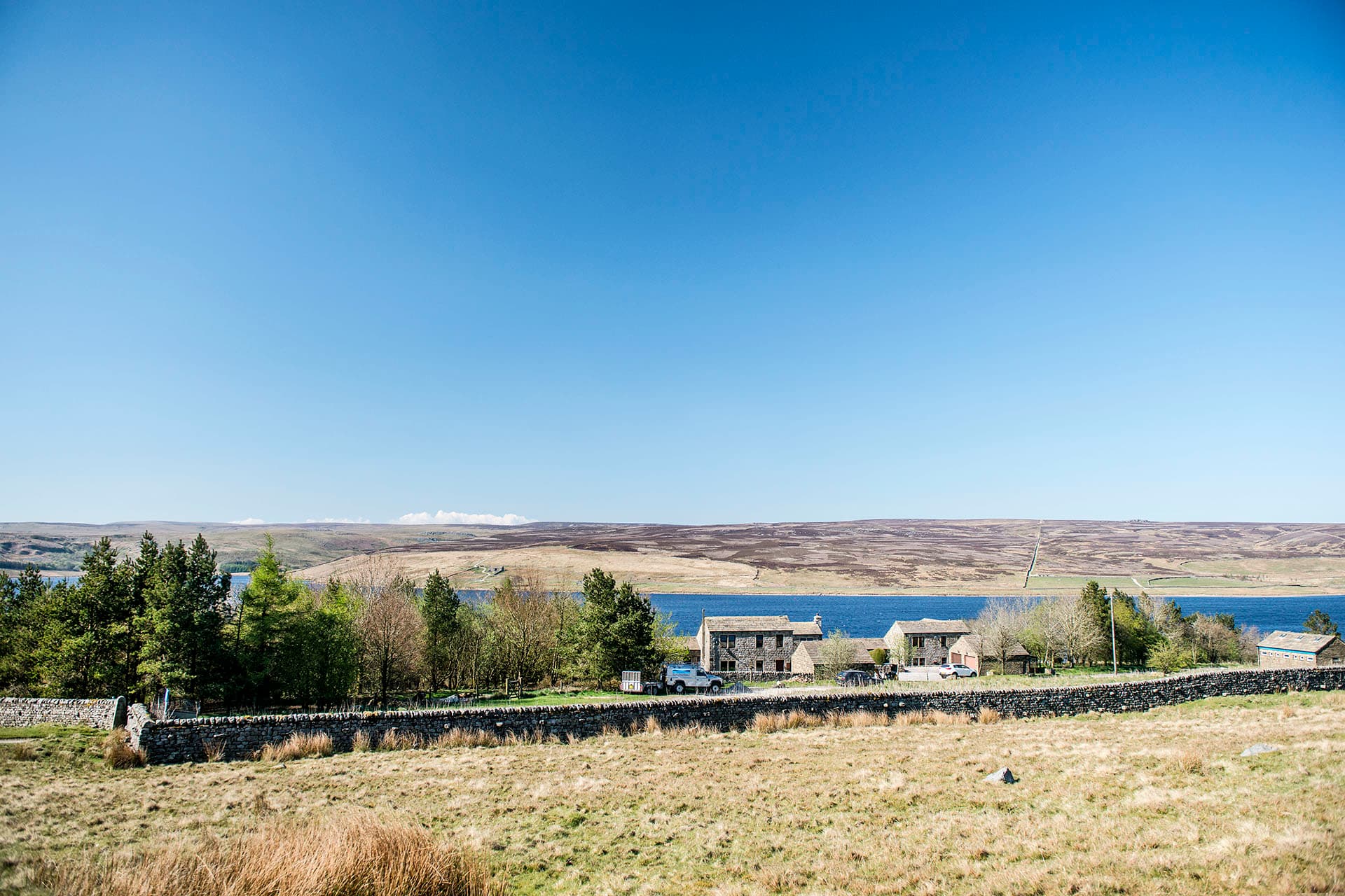 Grimwith House and the reservoir seen across the open Dales valley